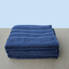 pile of clean terry cotton blue towels, close-up, on a light background, copy space, concept of...