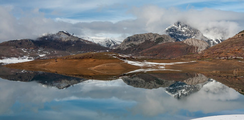 Porma reservoir, Susaron peak snowy and its reflection in the water. Lion. Spain