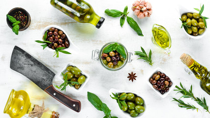 Olive oil and olives on a white wooden background. Top view. Free space for your text.