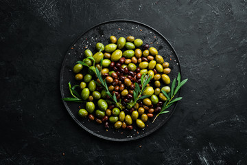 Olives in a bowl, olive oil, spices and herbs. Top view. Free space for your text.