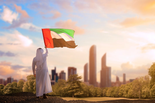 Emirati Arab man holding UAE flag, celebrating the national day