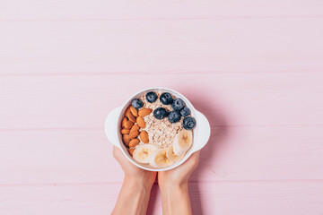 Woman's hands holding bowl of oatmeal