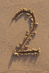 Number one written on a sandy beach. Handwritten characters collection.
