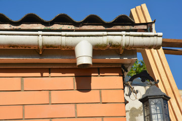 Brick house and rain gutter pipeline repair. Roof gutter fix
