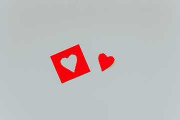 Little red paper heart and red frame with shape of heart on the light grey background. Saint Valentine s Day concept. 