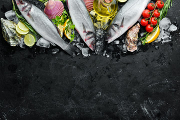 Sea fish seabass. Seafood on a black stone background. Top view. Free copy space.