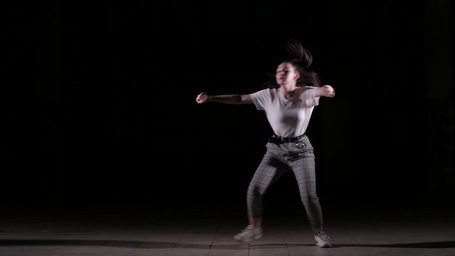 young woman dancing vogue, hip hop, street dancing in the studio on a black background, isolated