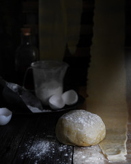 food photography of dough side view for making homemade pasta in a dark rustic style