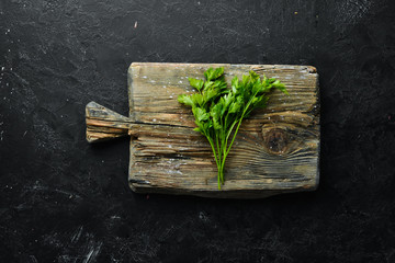 Fresh parsley on a wooden board. Top view. Free space for your text.