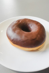 Chocolate donut on white plate