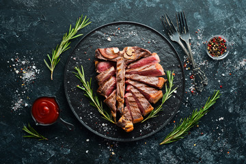 Sliced roast veal steak with rosemary and spices. Top view. Free space for your text.