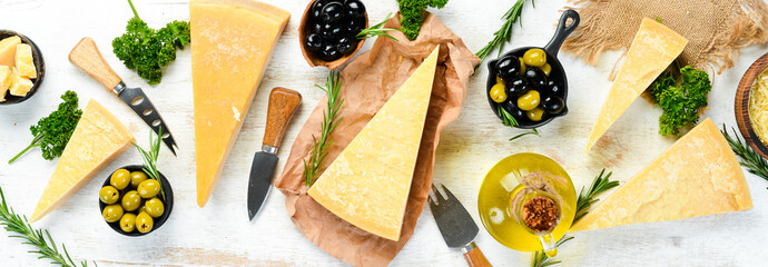 Assortment of hard cheeses on white wooden background. Parmesan. Top view. Free space for your text.