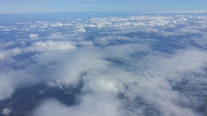 Sky above the clouds looked upon from the window of an airplane