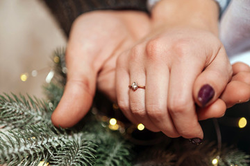 Hands with a wedding ring in the Christmas decorations, the bride and groom, winter, macro,...