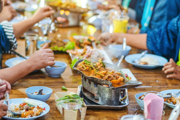 Group of female friends enjoy eating with acacia pennata omelette sour soup in fish shape hot pot in the restaurant. Selective focus.