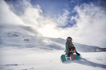 Fototapeta na wymiar snowy day at winter mountains . Snowboarder with snowboard