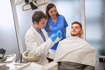 Obraz na płótnie Canvas Man at dentist in dental chair