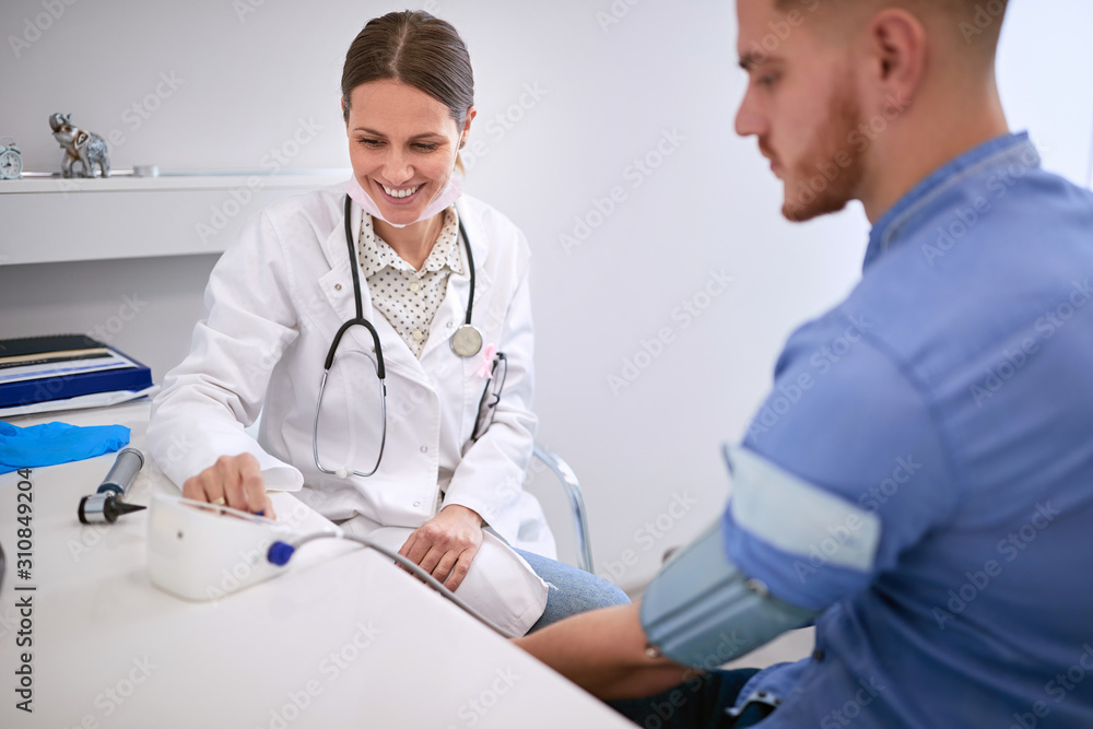 Wall mural doctor measures blood pressure to patient