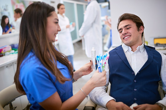 Dentist showing best toothbrushes and toothpaste to patient