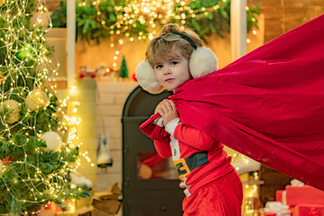 Believe in christmas miracle. Wish to meet santa claus. Boy child play near christmas tree. Santa boy celebrate christmas at home.