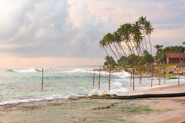 Stormy sunset in Koggala, Sri Lanka, in the water the sticks where fishermen perch.