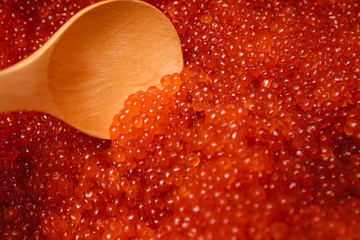 Red caviar in a wooden spoon.