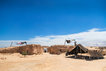 Small underground troglodytes traditional house situated in Sahara desert. Washed clothes hanging...