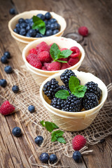 Blackberries, raspberries and blueberries in a waffle bowls.