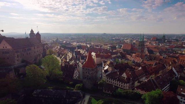Aerial rising city with a castle in the foreground at beautiful sunrise in 4k