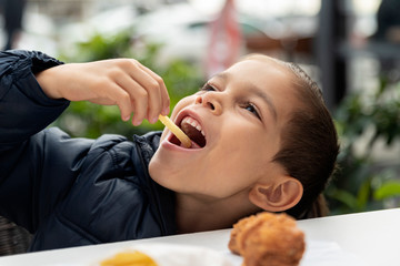 Obraz premium little boy eats french fries and chicken