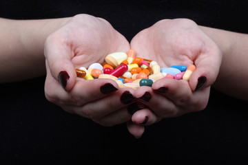 with hands cuffed and medicine pills on black background