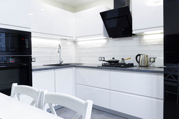 Interior of a modern white kitchen with built-in appliances. Compact minimalist kitchen.