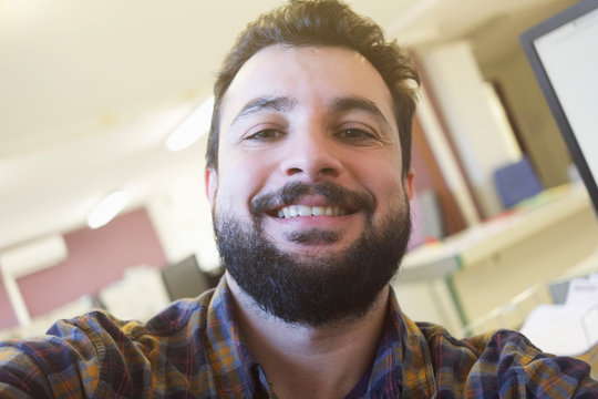 Man Taking Self Portrait In His Office With Camera