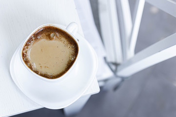 morning coffee with milk on a background of white kitchen interior.