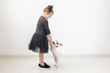 Pets and animal concept - Child girl playing with puppy Jack Russell Terrier.