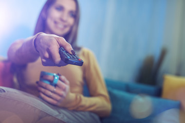 Woman holding a remote control and watching TV