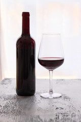 Wine bottle with  Red wine  glass on the black background. Luxury wine tasting concept.