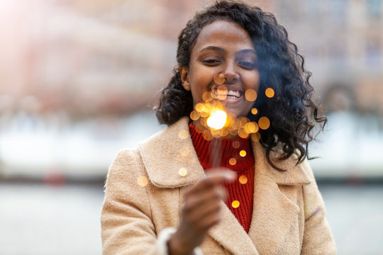 Happy woman at Christmas holding burning sparkler 