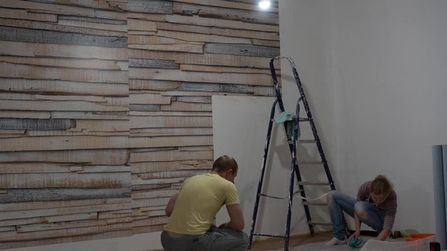 apartment repair and decoration. woman glues photo wallpaper on the wall. accelerated video