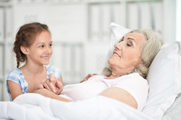 Fototapeta premium Portrait of granddaughter with grandmother sitting at home