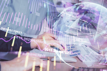 Multi exposure of chart with man typing on computer in office on background. Concept of hard work.