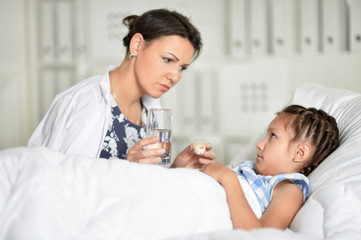 Portrait of sad woman with daughter in hospital ward