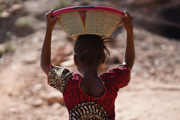 Candid Picture of Ethnic African Schoolgirl with Colorful Shirt and Basket