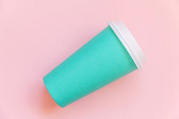 Simply flat lay design blue paper coffee cup on pink pastel colorful trendy background. Takeaway drink container. Good morning wake up awake concept. Template of drink mockup. Top view copy space