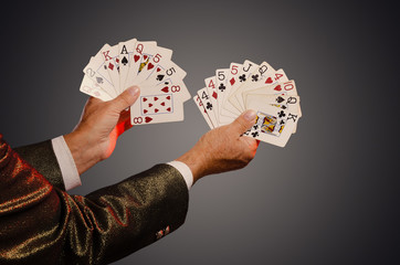 Magician shows trick with playing cards. Sleight of hand. Manipulation with props.