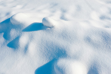 White snow texture on the sun. Winter snowy background of fresh snow with hills surface in blue tone.