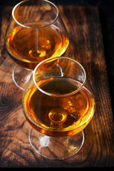 Two glasses of brandy or cognac on  dark table