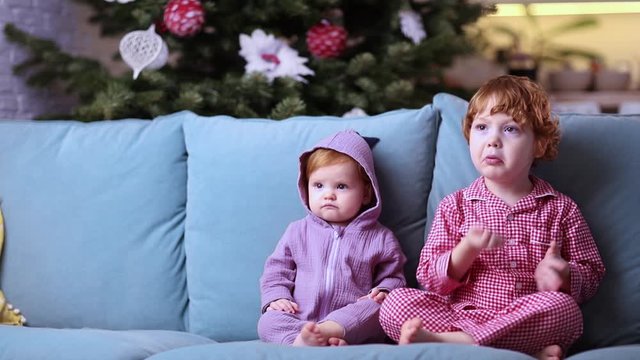 cute little kids, siblings are watching cartoons on tv at home