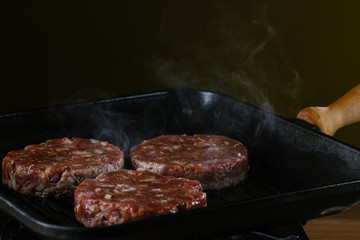 Burger patties are fried in a pan 