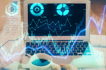 Stock market graph on background with desk and personal computer. Multi exposure. Concept of financial analysis.